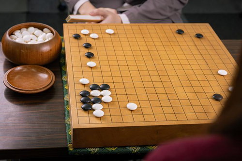 白ノゾキから黒一段に迫る局面の囲碁対局、緊張感漂う真剣勝負