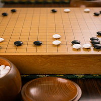 定石後の盤面で繰り広げられる迫力の攻め合い、白黒の碁石が激しく対峙の写真