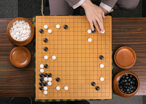 軽いサバキで活路を開く対局の碁盤での白石を置く手元