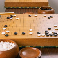 堅いシマリへのツケから始まる囲碁のサバキの手順を指導する様子の写真