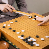 白陣を分断するツケで反撃に転じる決意の一手を打つ囲碁の対局の写真