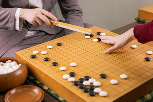 白陣を分断するツケで反撃に転じる決意の一手を打つ囲碁の対局