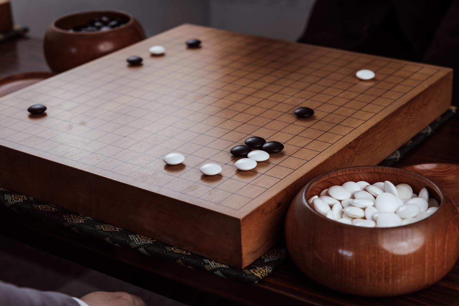 木製の碁盤に黒白の碁石で囲碁の定石を配置した盤面