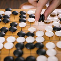 プロ棋士が複数個の黒石を一気に取る決定的瞬間の写真
