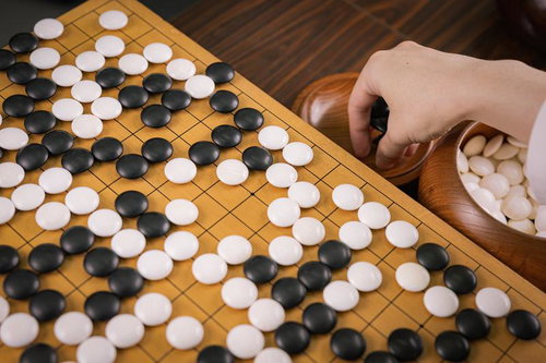 取り上げた石を丁寧に碁笥の蓋へ、得点を刻む静かな所作