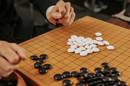 囲碁の終局後、黒白の碁石を碁盤から丁寧に分ける様子