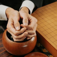 囲碁あるある：両手で包み込むように持つ、碁笥から石を効率的に運ぶ方法の写真