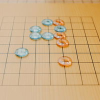 九路盤上に並べたアクリル碁石の配置と対局準備の写真