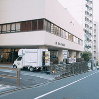 囲碁の総本山「日本棋院」前の帯坂、白い建物と細い石畳の道の写真