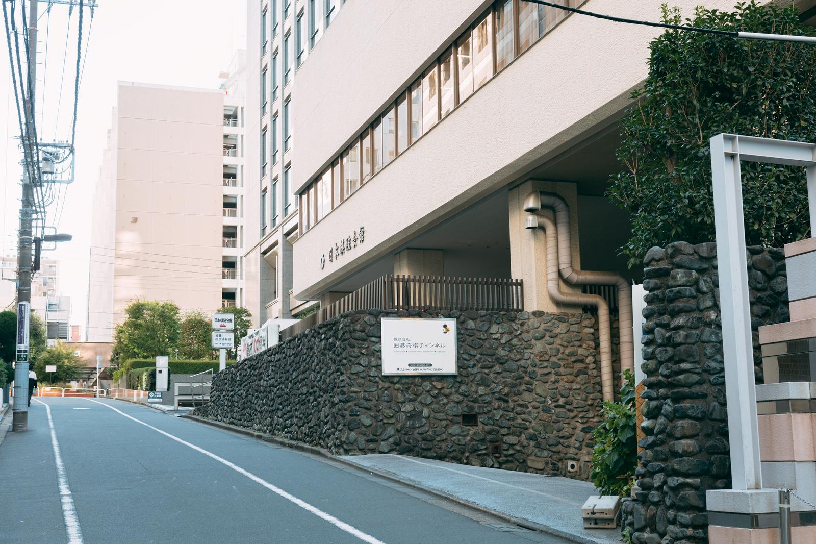 石積み護岸と建物が立ち並ぶ日本棋院前の坂道
