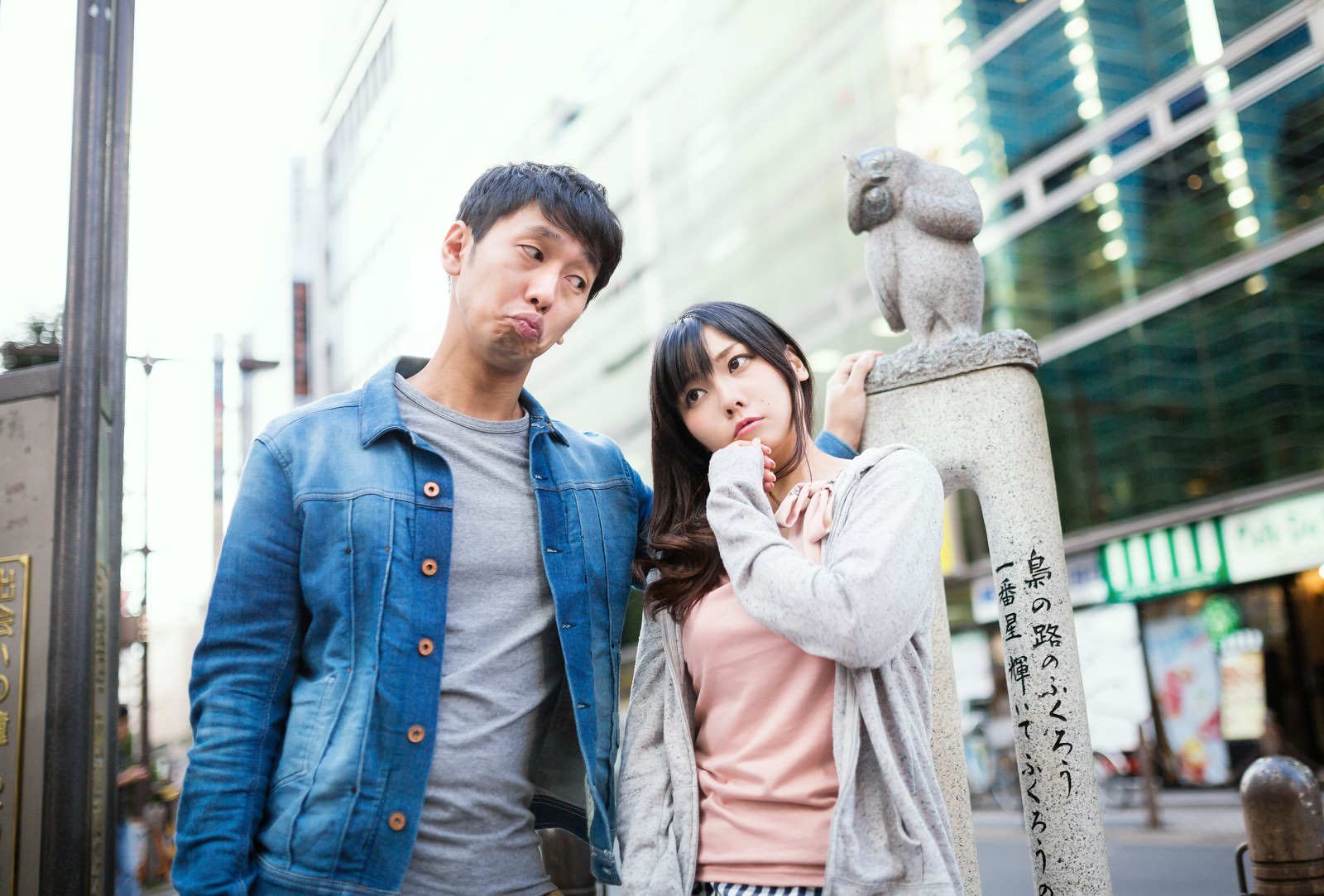 池袋駅前の狛犬の前で、困った表情でデートコースを悩む男女二人［モデル：大川竜弥 Lala］