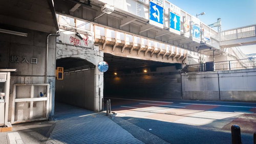 南池袋のびっくりガード入口と道路標識、高架橋下の街並み