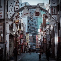 池袋の西一番街にそびえる特徴的なゲートと居酒屋街の夜景の写真