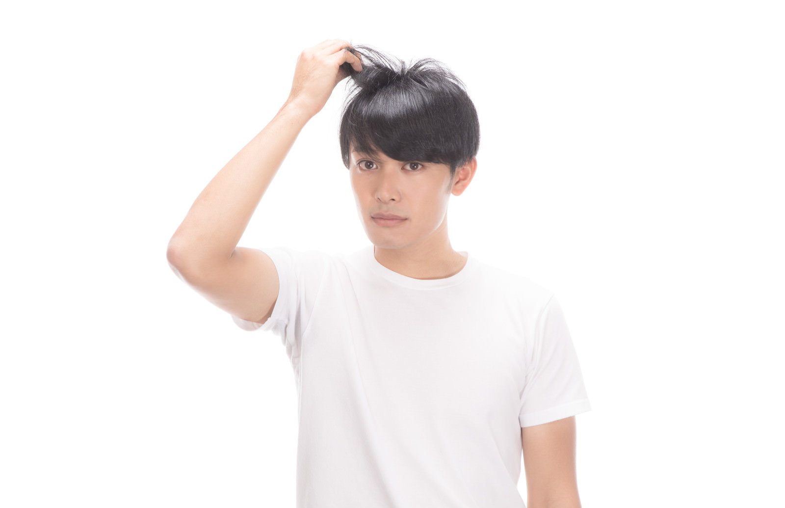 頭に手を当てて困った表情をする白いTシャツの男性［モデル：完伍］