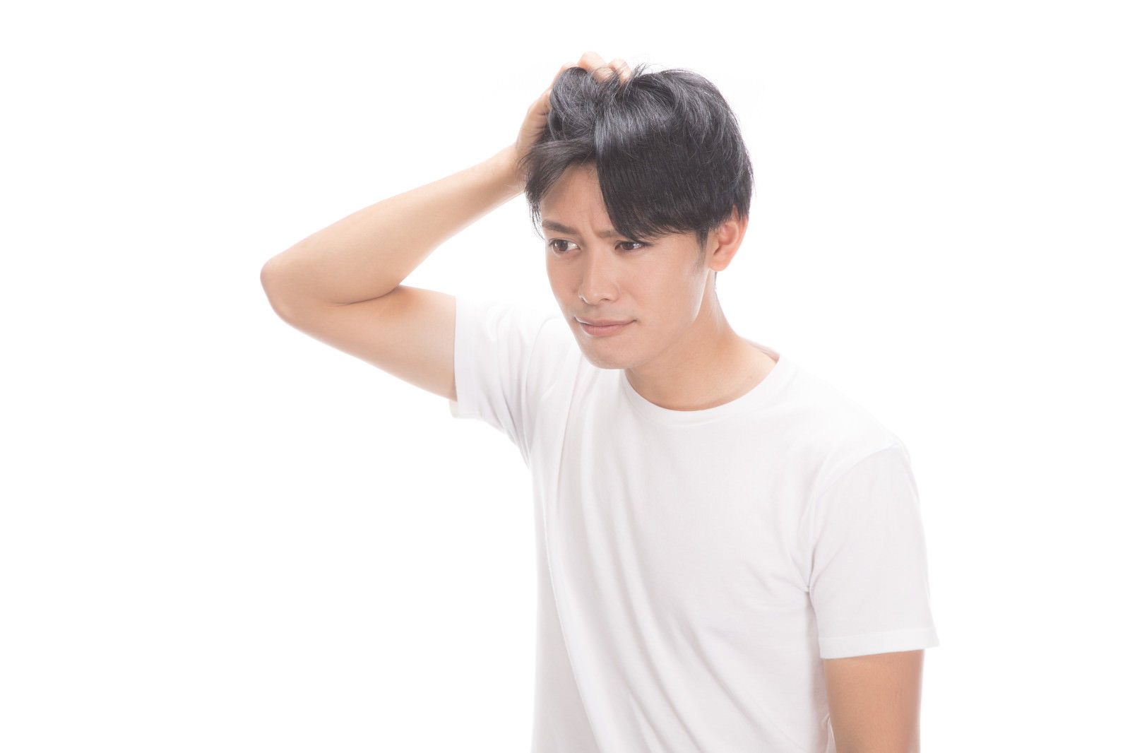 白いTシャツを着た若い男性が片手でおでこに触れて悩んでいる様子［モデル：完伍］