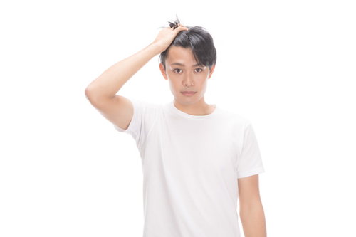 前髪をあげておでこの広さを見せる若い男性