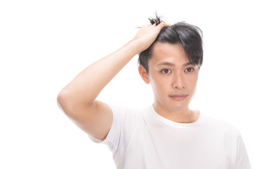 生え際をチェックする若い男性