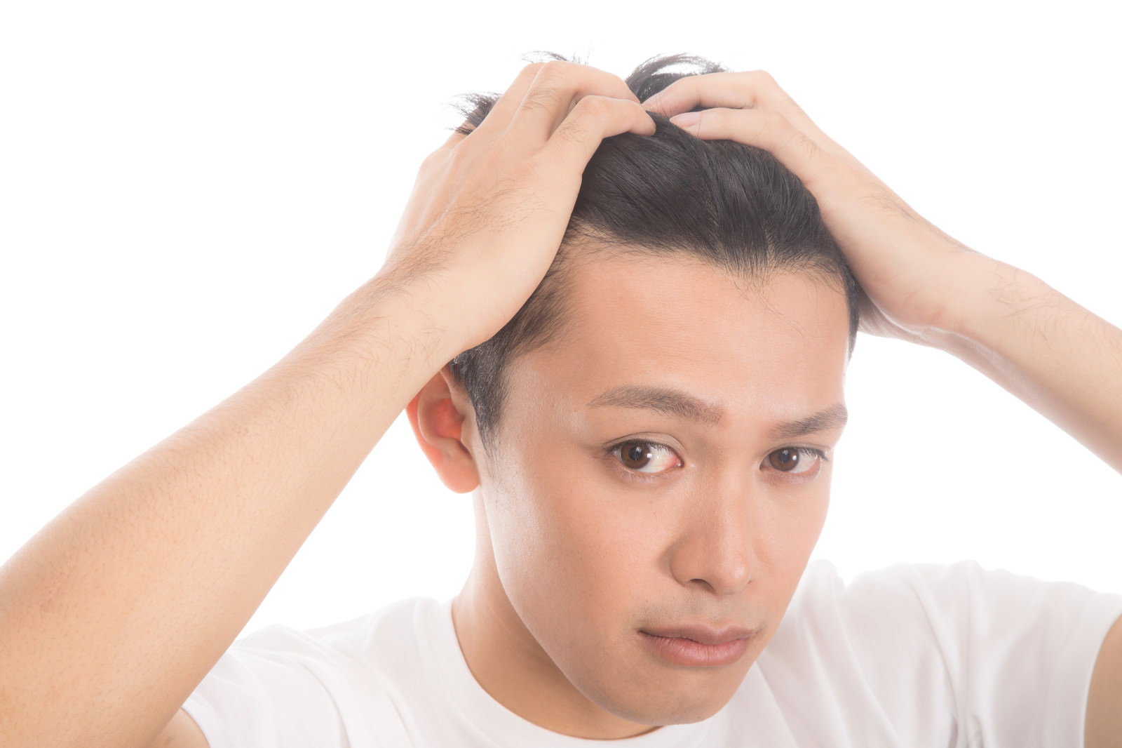 白背景で両手で髪をかきあげておでこと生え際を見せる男性［モデル：完伍］