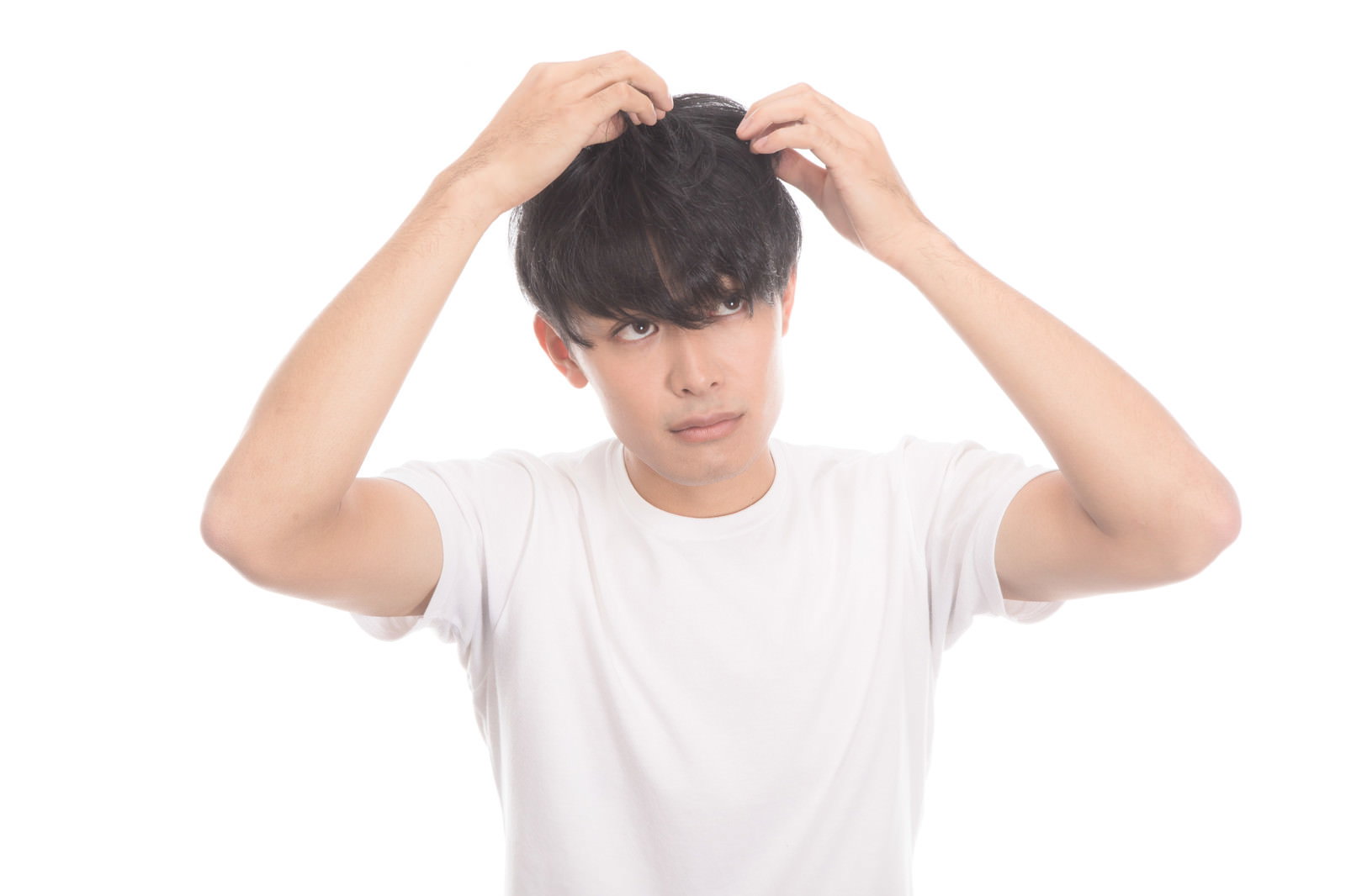 白いTシャツを着た男性が両手で頭髪を気にしている様子［モデル：完伍］
