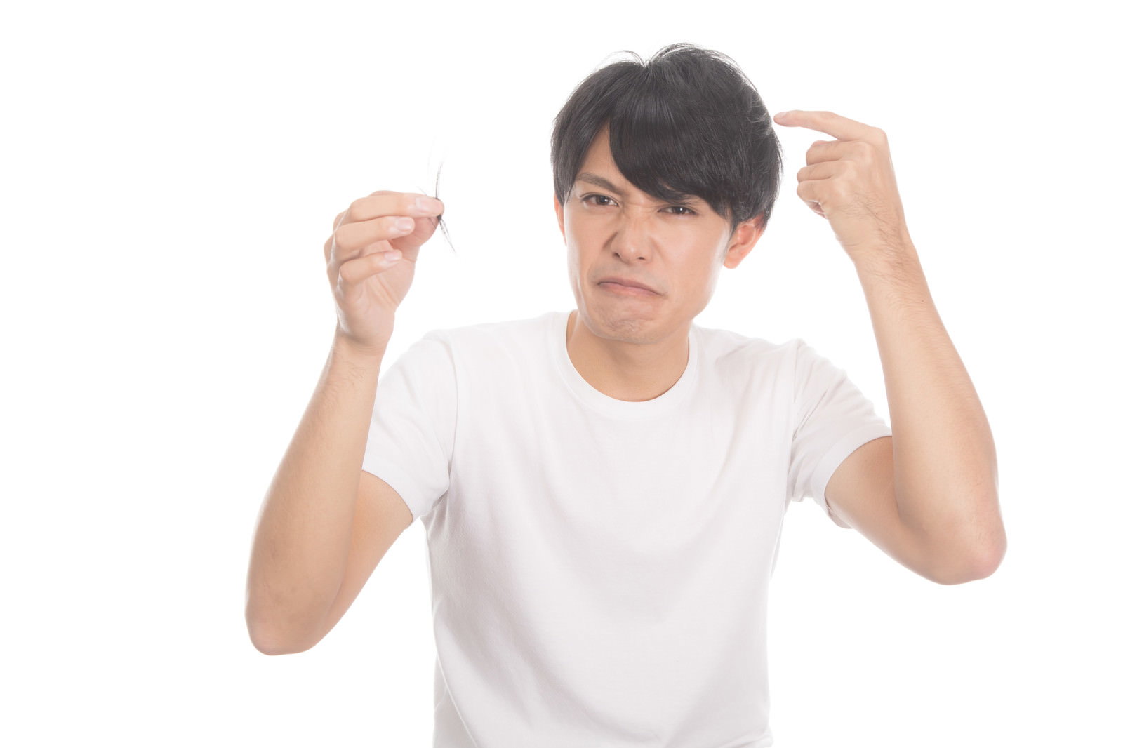 両手を頭の上に置いて髪の抜け毛を気にする表情の若い男性［モデル：完伍］