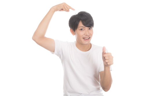 ヘアケアで満足している若い男性のガッツポーズ