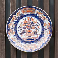 木塀に掛けた伊万里焼の装飾皿、青白の鳳凰文様の写真