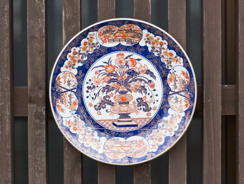 木塀に掛けた伊万里焼の装飾皿、青白の鳳凰文様