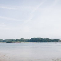 イマリンビーチから見える対岸の造船所と穏やかな海の写真