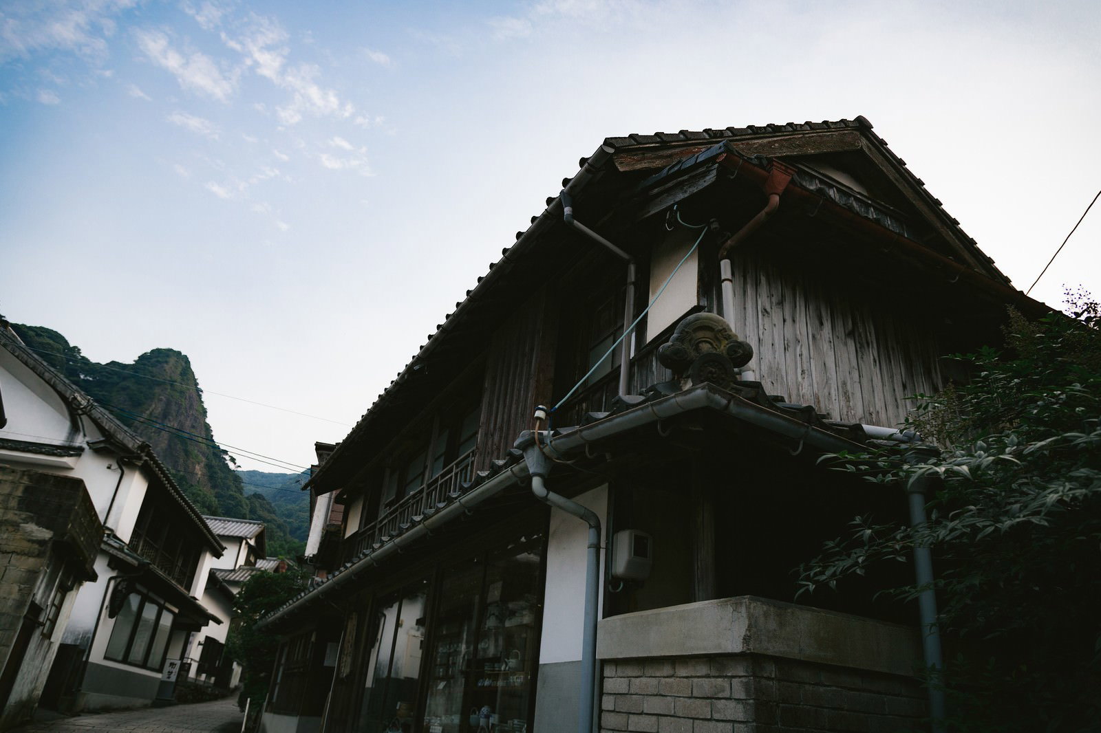 茅葺き屋根の古民家と白壁の建物が山間に佇む大川内山の風景