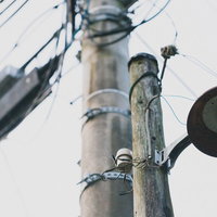 電柱に取り付けられた古びた街灯と電線が交差する夜景のの写真