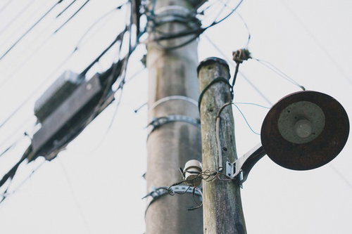 電柱に取り付けられた古びた街灯と電線が交差する夜景の