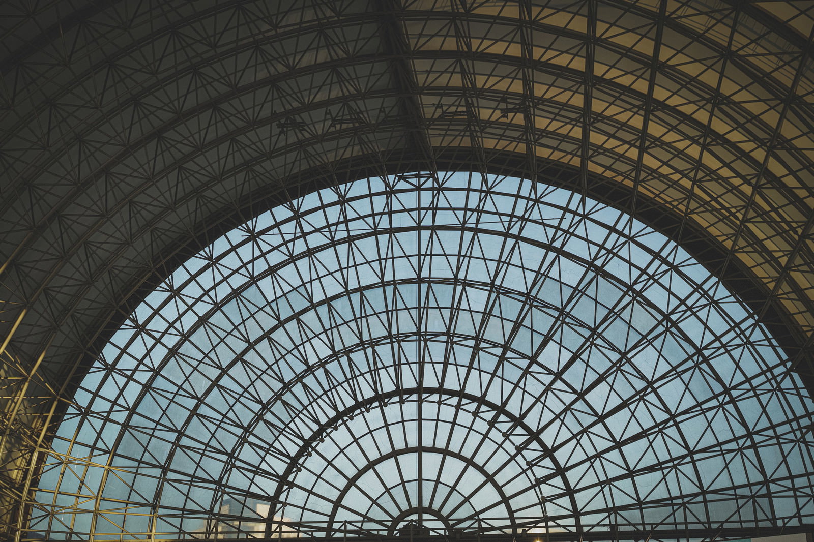 分度器の形をした半円状のガラス屋根を持つインテックス大阪の内部構造