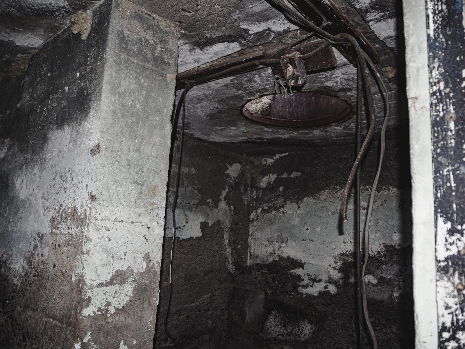 コンクリート壁の廃ビル内に置かれた錆びた釣り竿と古い洗面台