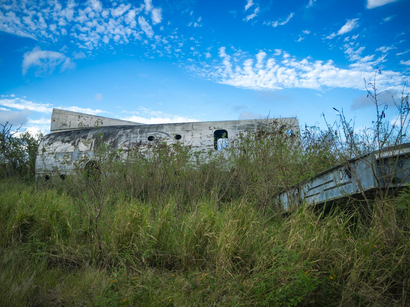 硫黄島の草むらに朽ちた米軍C-124輸送機の残骸が横たわっている