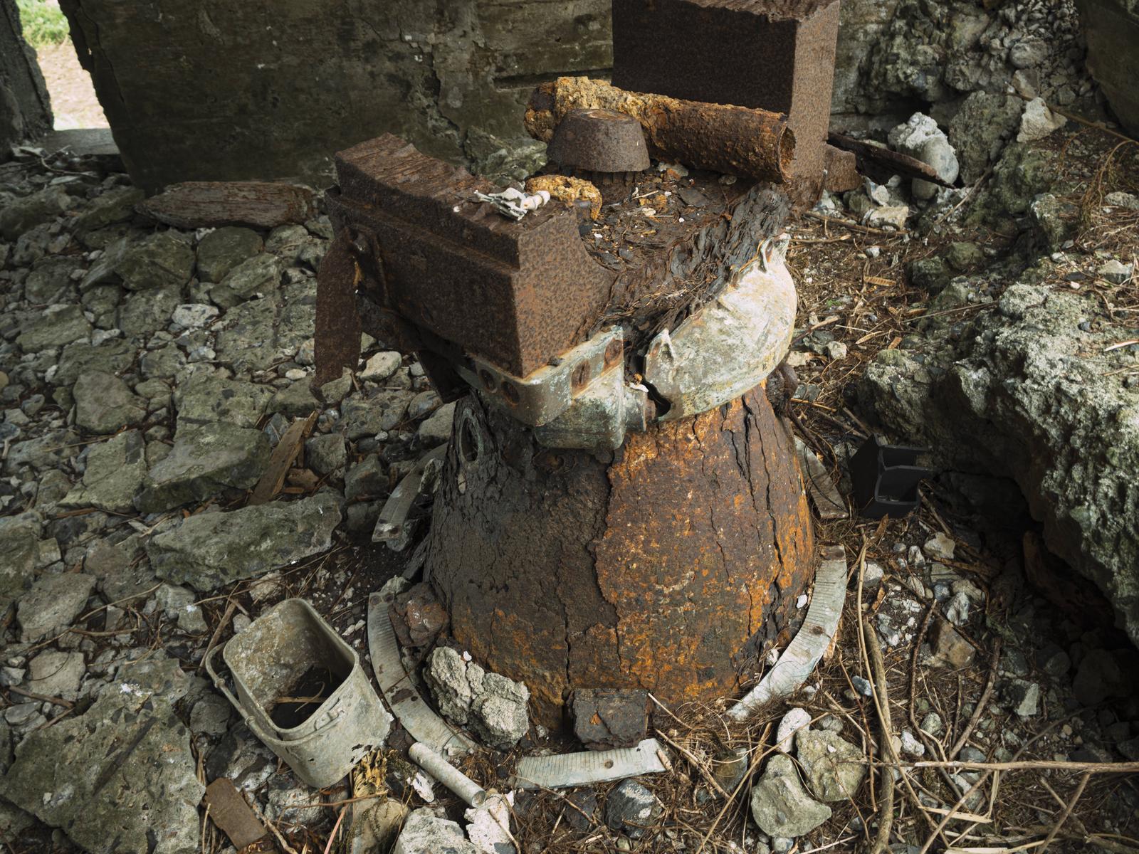 錆びた金属と破損したコンクリートで劣化した12糎砲砲座の遺構