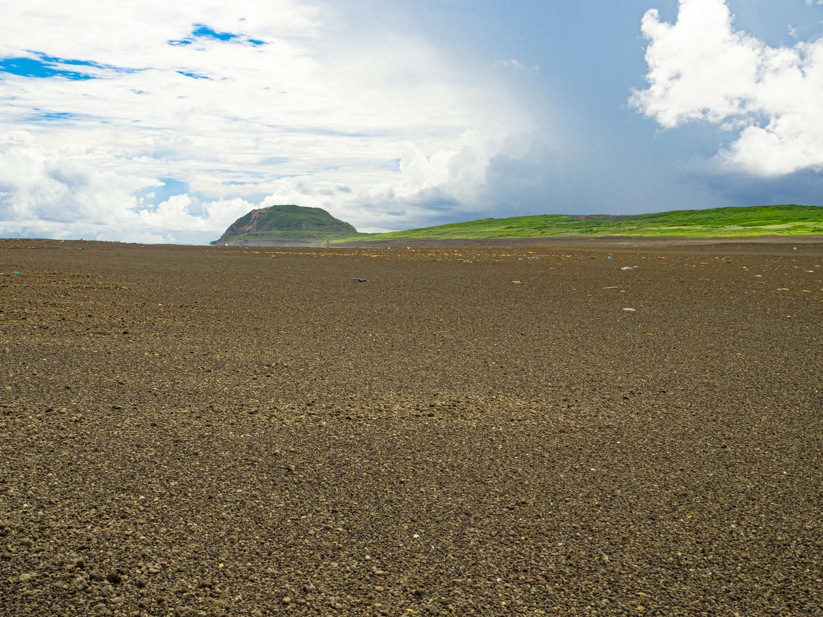 黒い砂浜の向こうに摺鉢山が見える硫黄島の翁浜の風景