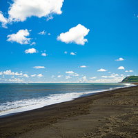 軽石などが大量に流れ着いた翁浜と摺鉢山の写真