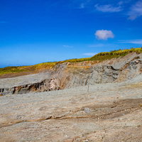 硫黄島西側の荒れ地にぽっかりと口を開けた鶯地獄（阿蘇台陥没孔）の写真