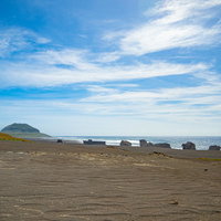 千鳥ヶ浜（西海岸）の沈船群と奥に霞む摺鉢山の写真