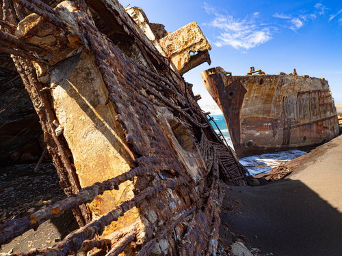 海底の隆起によって砂浜へと押し上げられた戦後米軍の港湾整備のために沈められた船の残骸