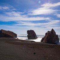 黒い砂浜に打ち上げられた硫黄島の沈船残骸の写真