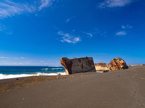 美しい青空と青い海の中で砂浜に横たわる米軍が港湾整備のために沈めた船の残骸