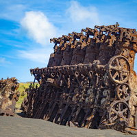 海底隆起によって姿を現し亜熱帯の太陽に焼かれる錆びて赤茶けた沈船のエンジンなどの写真