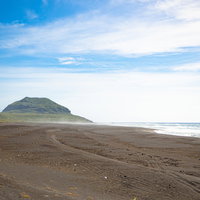 砕けた波の飛沫が強い風に乗って流れまるで砂浜から沸き立つ霞に覆われたような千鳥ヶ浜の写真