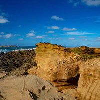 荒涼とした姿を見せる硫黄島・釜岩と海上にかすむ監獄岩の写真