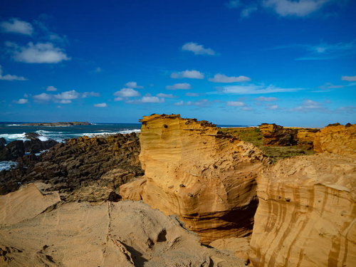 荒涼とした姿を見せる硫黄島・釜岩と海上にかすむ監獄岩