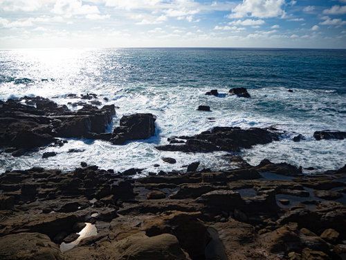 釜岩に打ち寄せる波と光り輝く海原