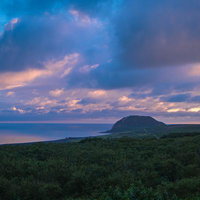 摺鉢山と空を覆う夕暮れに染まる雲の写真
