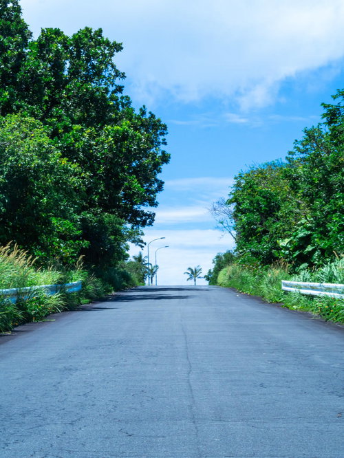 夏の日差しに焼け奥の景色がゆらめく坂道