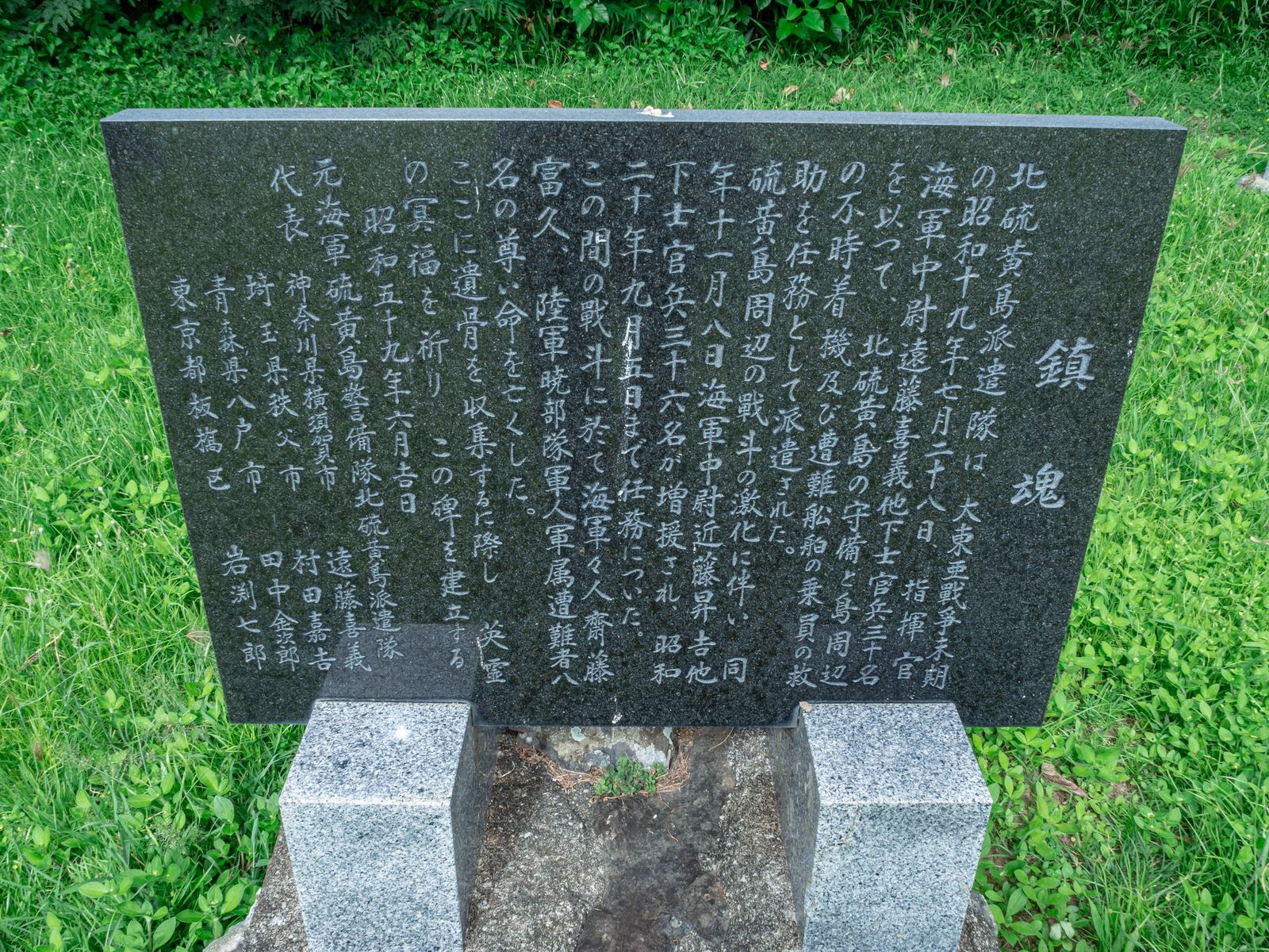 緑の芝生に建つ黒い石の慰霊碑